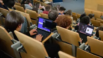 Students with laptops sitting in a lecture hall