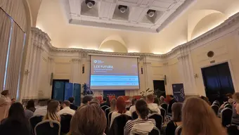 Sala konferencyjna wypełniona ludźmi. Wyświetlana jest prezentacja Lex Futura.