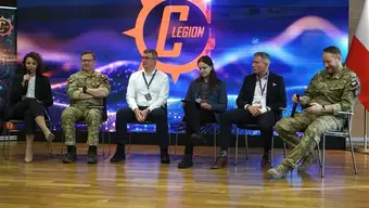 Sześć osób siedzących na sali. W tle baner Cyber Legion.