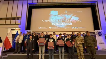 Grupa osób na scenie z wręczonymi nagrodami.