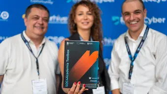Three people holding printed SOC for Academia toolbox